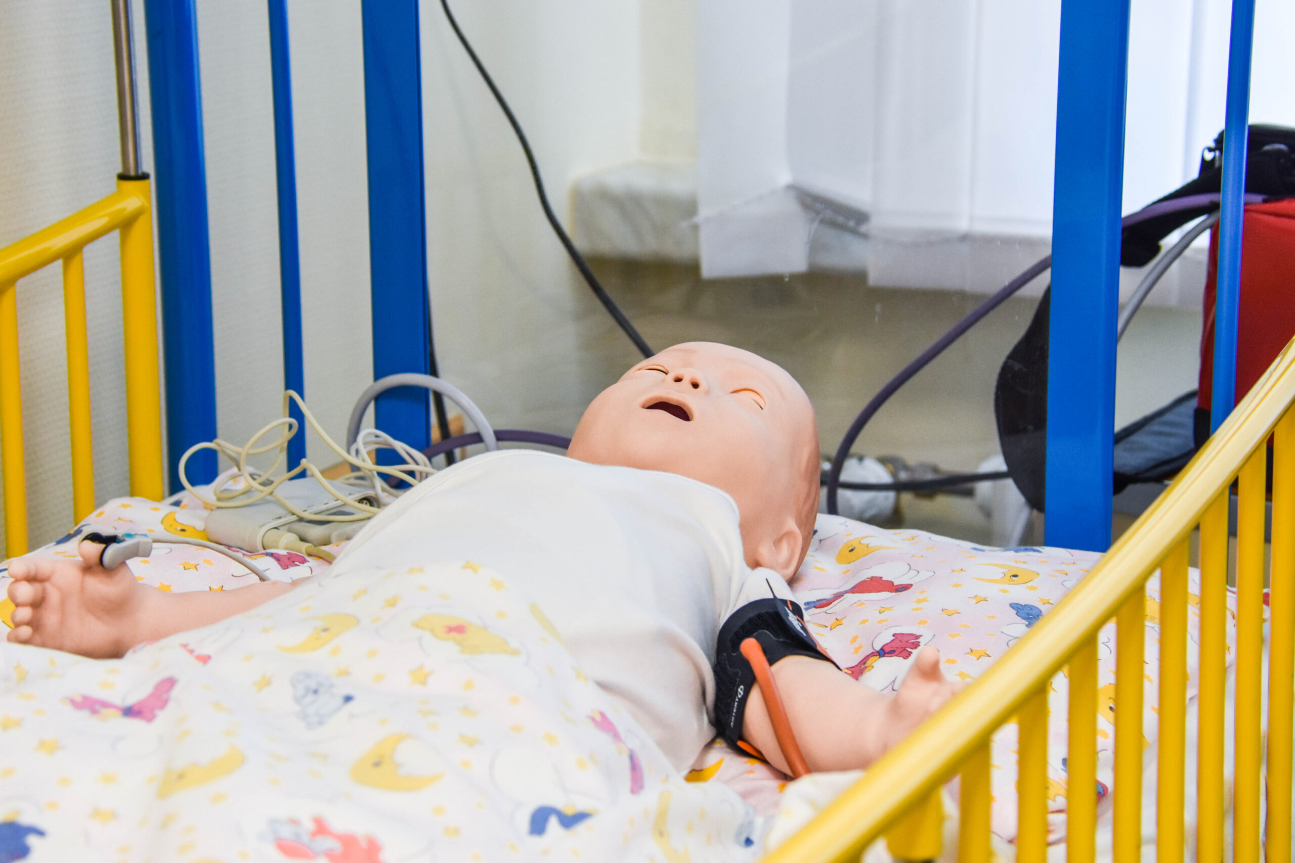 Eine medizinische Babypuppe in einem Krankenhausbett